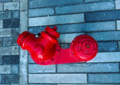 A red fire hydrant is seen close to the ground on a sidewalk. The surrounding Stock Photos
