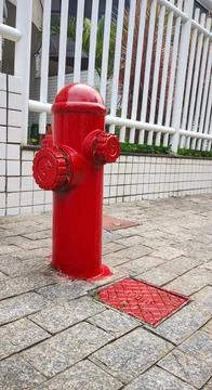 Red fire hydrant on the sidewalk of a residence Stock Photos