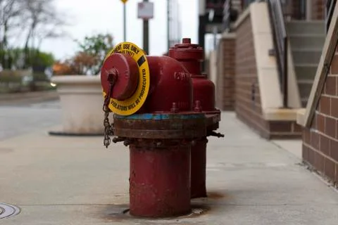 A red fire hydrant sitting on the sidewalk Stock Photos