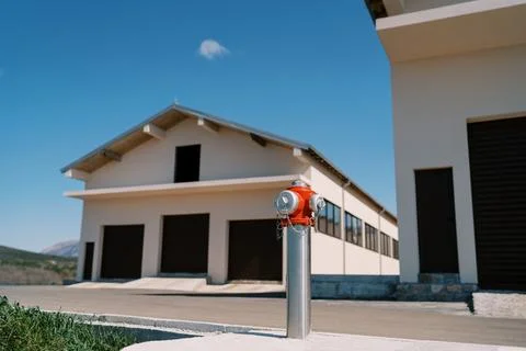 Red fire hydrant stands on the road near the house Fotos Stock