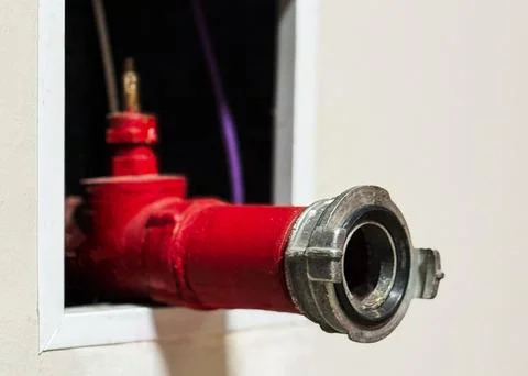 The red fire hydrant system powerful on the white cement wall. Stock Photos