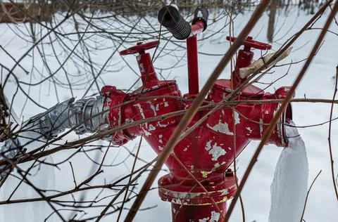 Red fire hydrant V - shaped with frozen water jet Stock Photos