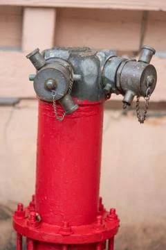 Red fire hydrant water pipe with a chain on the street Stock Photos