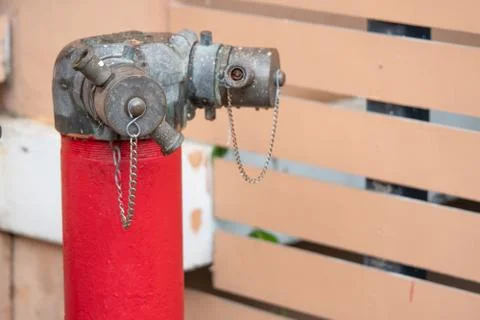 Red fire hydrant water pipe with a chain on the street Foto stock