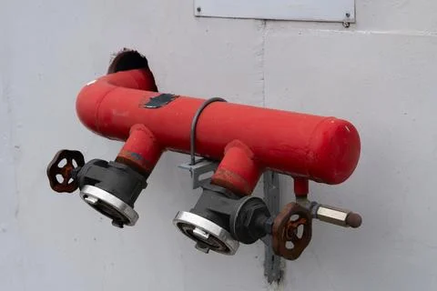 Red fire hydrant on white wall. Close-up. Stock Photos