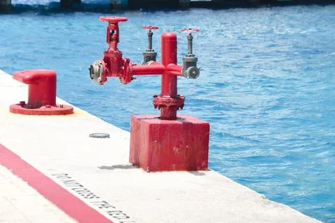 Red fire pump connection on a harbor pier Stock Photos