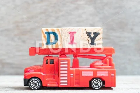 Red fire truck hold letter block in word DIY (abbreviation of do it yourself) Stock Photos