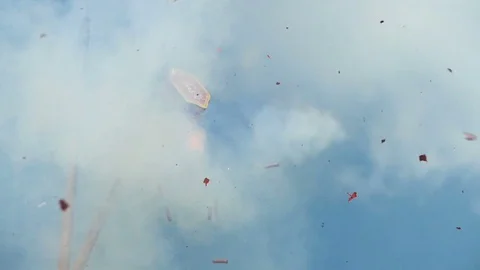 Red firecracker explodes against blue sky Stock Footage 79248811