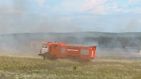 Red firemachine moving accros field Stock Footage 65303037