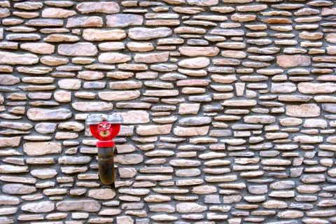Red fireplug at old style stone wall Stock Photos