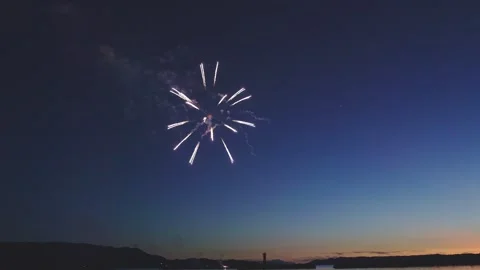 Red firework blossoming in dusk sky over sea during Japanese festival Stock Footage 340632659