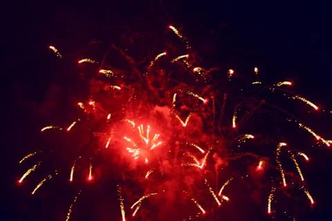 Red firework explodes against dark night sky Foto stock