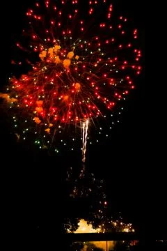 Red firework exploding above the Grand River on the 4th of July Stock Photos