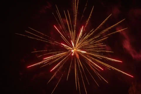 Red firework exploding in sparks and smoke at night Foto stock