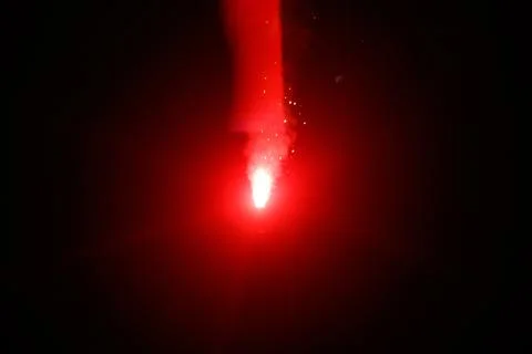 A red firework is lit up in the dark Stock Photos