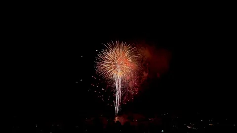 Red Fireworks Bursting Over Town at Night on July 4th, Aerial View, 4K Vídeo Stock 338305553