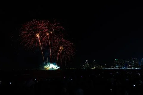 Red Fireworks Display Exploding Over Pattaya City Skyline And Ocean Coastli.. Foto stock