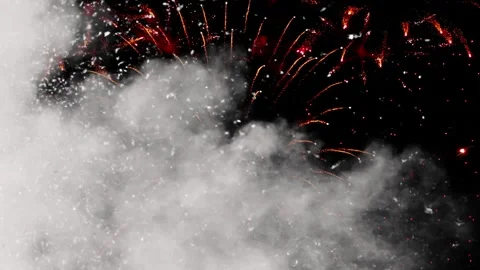 Red fireworks exploding behind thick white smoke clouds against a dark night Stock Footage 340612732