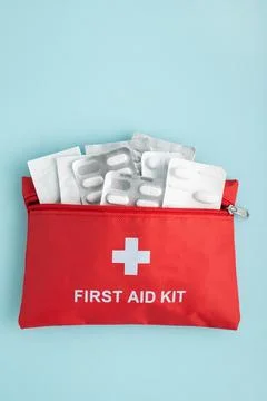 Red first aid kit bag with medicine blister packs Stock Photos