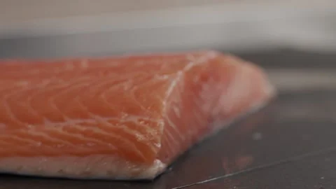 The red fish is cut into slices. Close up shot. Cooking sushi roll. Black textur Video stock 145343411