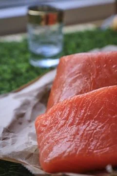 Red fish on the table, a slice of fish, seafood and alcohol, green lawn, salted Stock Photos