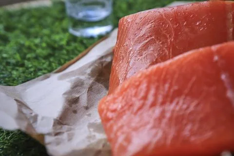Red fish on the table, a slice of fish, seafood and alcohol, green lawn, salted Stock Photos
