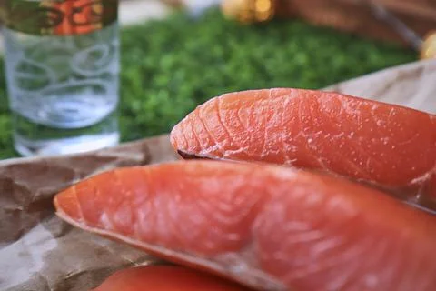 Red fish on the table, a slice of fish, seafood and alcohol, green lawn, salted Stock Photos