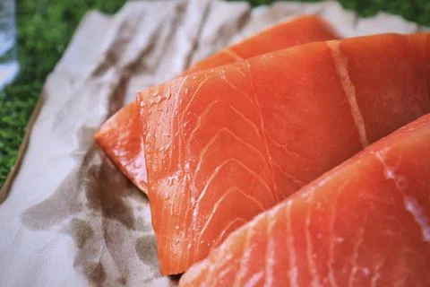 Red fish on the table, a slice of fish, seafood and alcohol, green lawn, salted Stock Photos