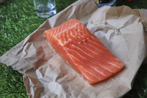 Red fish on the table, a slice of fish, seafood and alcohol, green lawn, salted Stock Photos