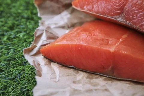 Red fish on the table, a slice of fish, seafood and alcohol, green lawn, salted Stock Photos
