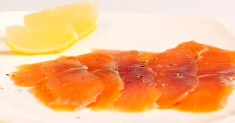 Red fish on a white dish with lemon and pepper Stock Footage 141946013