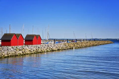 Red fisher houses behind the stone groyne at the harbor Weisse Wiek in Bolten Stock Photos