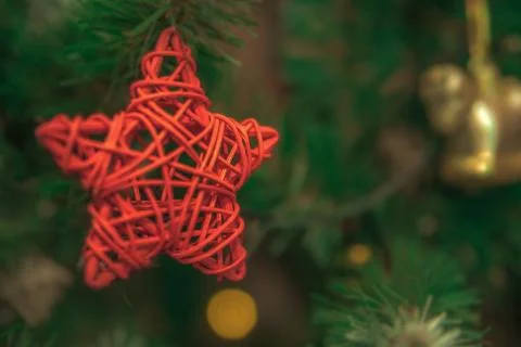 A red five-pointed star hangs on a Christmas tree Stock Photos