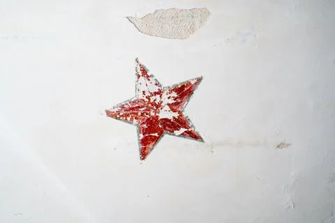 Red five-pointed star on the old wall. Stock Photos