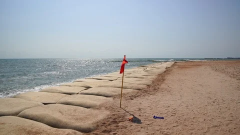 Red flag and dam by the Cha-am sea and sand bag warning. Stock Footage 103562472