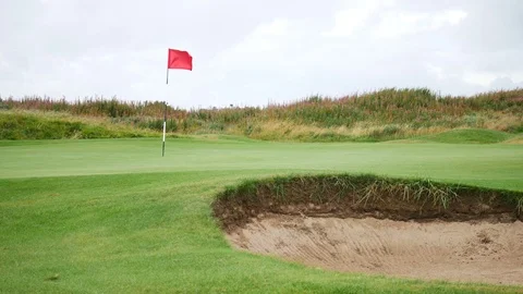 Red flag and sand bunker at the beautiful golf course in Newburgh Stock Footage 71160907