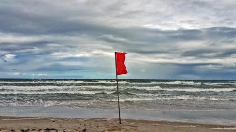 Red flag on the beach. Stock Photos