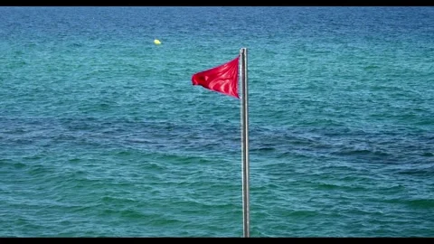 Red flag on the beach. Red flags wave in the wind on a windy but sunny summ.. Stock Footage 321896717