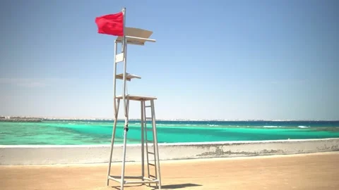 Red flag on the beach by the sea Stock Footage 152857970