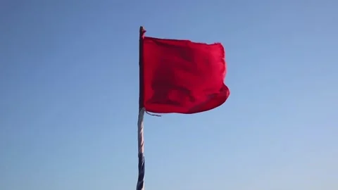 Red flag blowing in strong winds on beach background 스톡 동영상 339518057