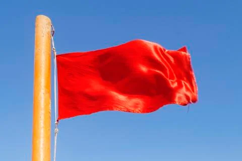Red flag to develop on the background of blue sky Stock Photos