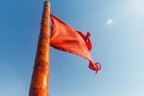 Red flag to develop on the background of blue sky Stock Photos
