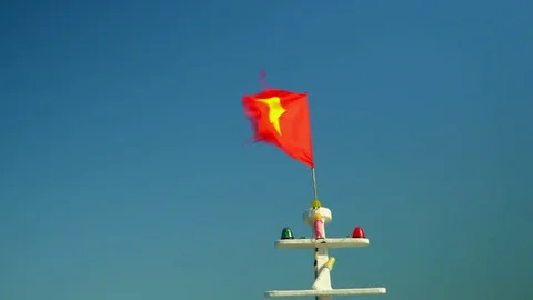 The red flag develops against the background of the blue sky. Vietnam.. Video stock 83997071