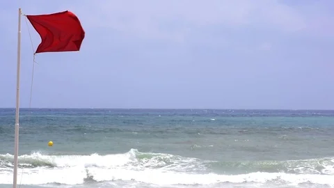 Red flag flapping in the breeze against seascape Vídeos de archivo 112957213