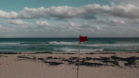 Red flag fluttering with the wind at the beach in scenic background Stock Footage 233437537