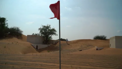 The red flag is fluttering in the wind in the desert. Abandoned village, close Stock Footage 220871869
