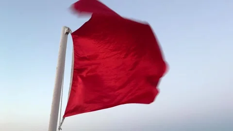 A red flag flutters in the wind in the sky Stock Footage 246443285