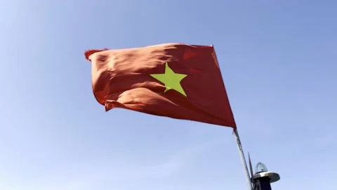 Red flag with gold star flapping in the ... | Stock Video | Pond5