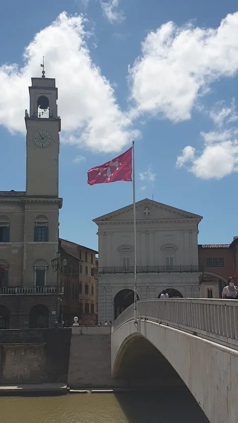 The red flag of Pisa waving in the wind on the bridge "Ponte di Mezzo", Arno Stock Footage 133915127
