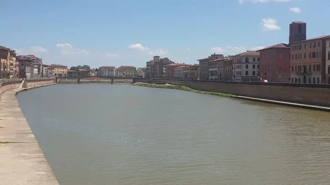 The red flag of Pisa waving in the wind on the bridge "Ponte di Mezzo", Arno Stock Footage 133915142